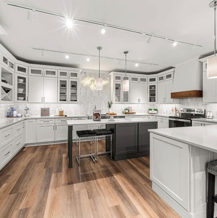 a newly remodeled modern kitchen with hardwood floors and white cabinets