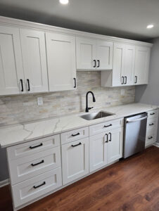 qualified remodelers remodeled kitchen with marble countertops and wood floors